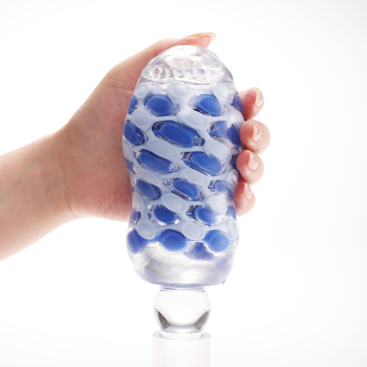 TENGA ARTE Marine Weave tenu en main sur son support de séchage en verre