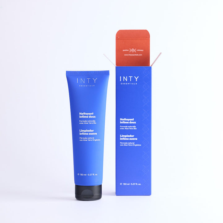 Nettoyant intime doux intyEssentials en dehors de son carton tube et packaging de couleur bleu majorelle avec des accents de brique contrastant